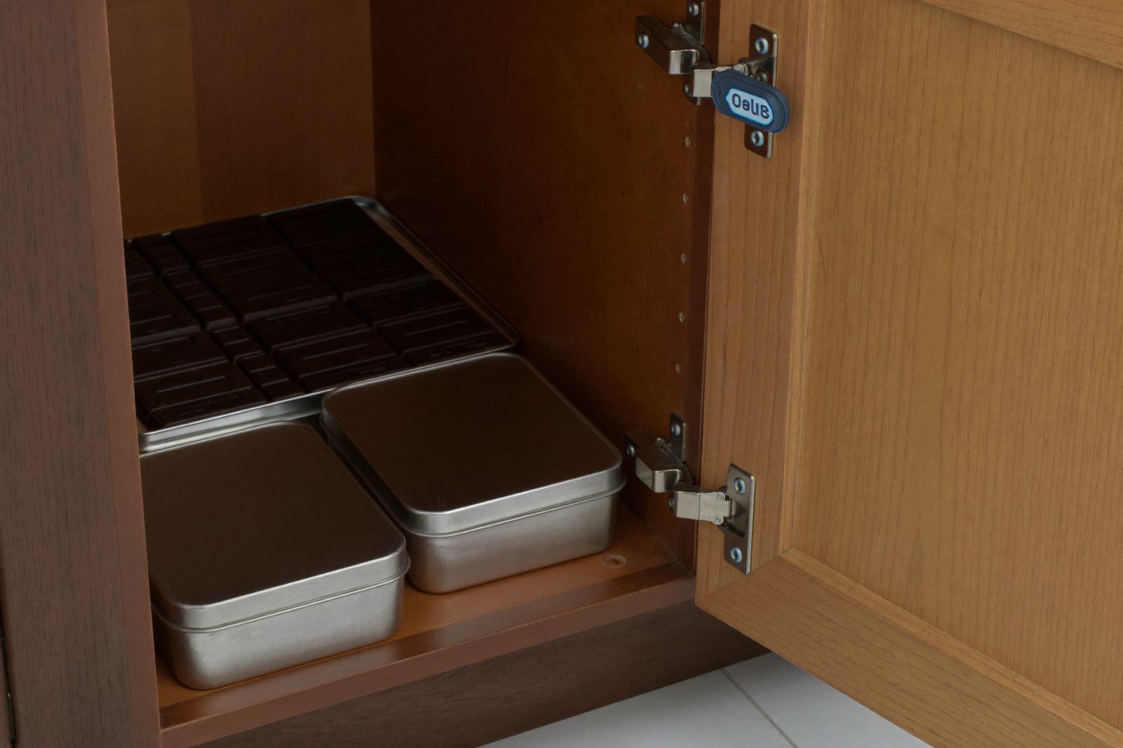 Barras de chocolate y latas guardadas dentro de una alacena con pestillo de seguridad