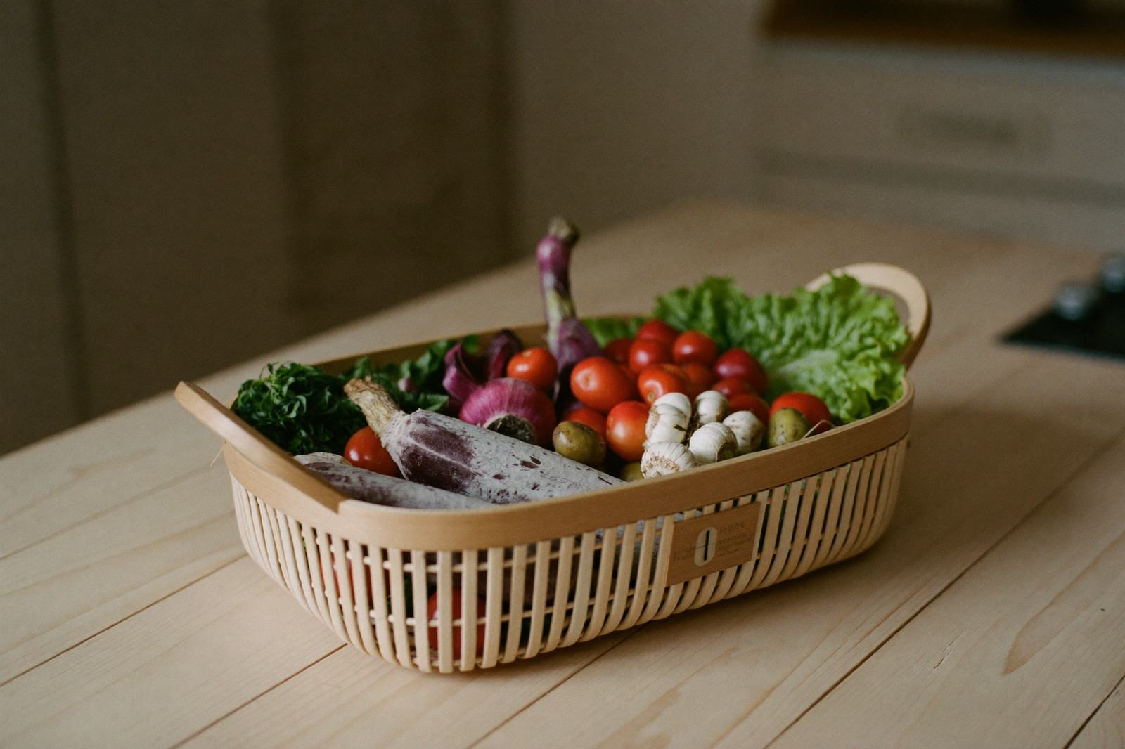 Canasta de mercado con verdura y fruta de temporada sobre una mesa de madera