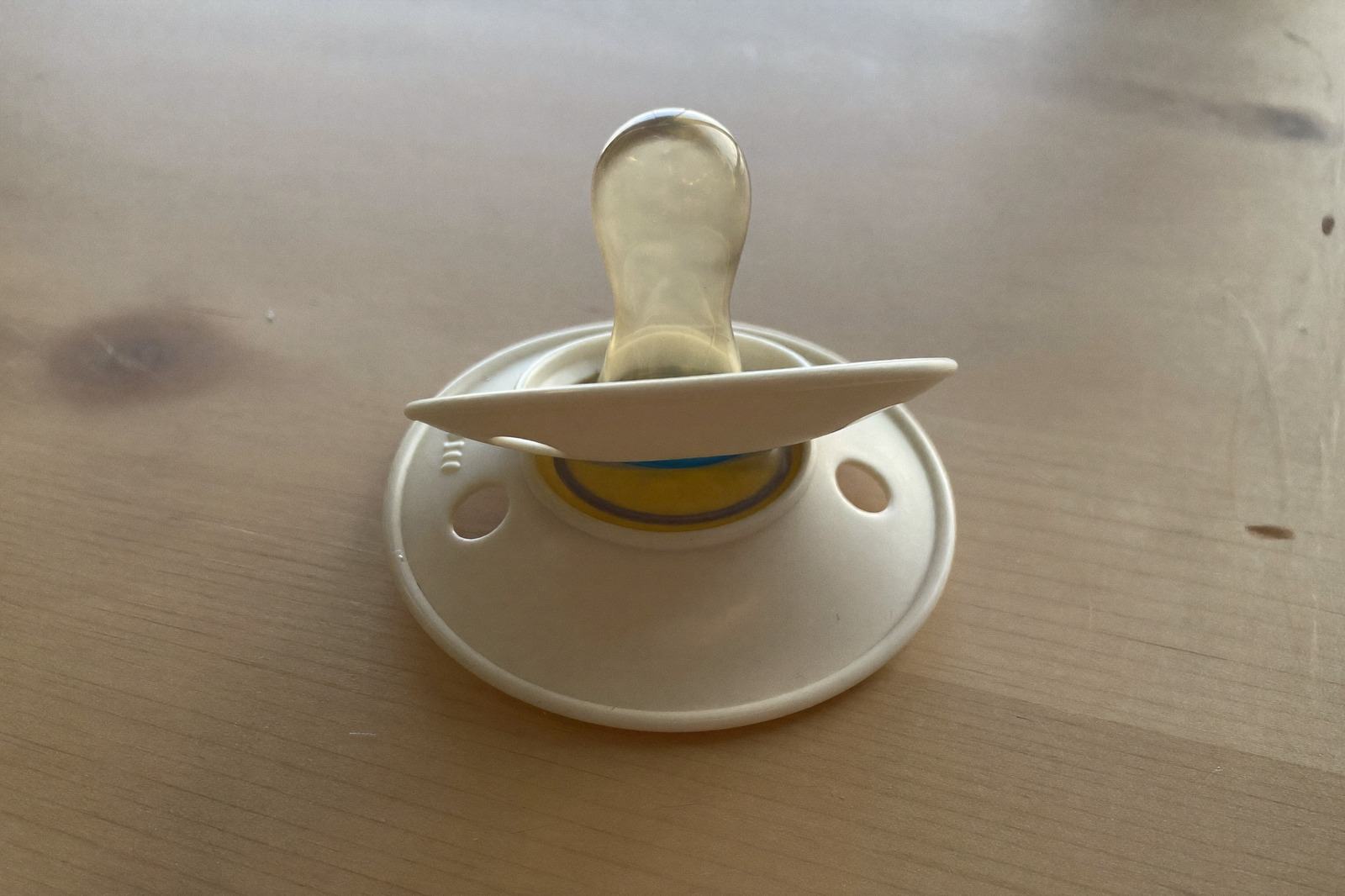 Chupón de una sola pieza apoyado sobre una mesa de madera clara