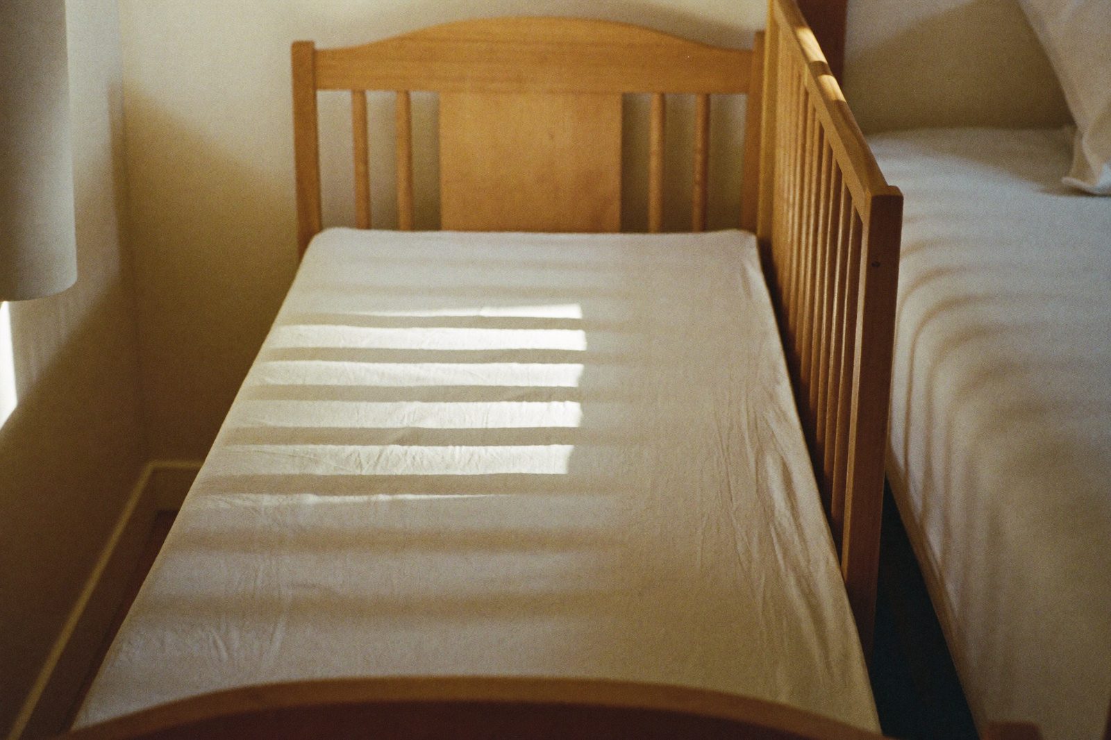 Cuna de colecho junto a la cama de los papás, con colchón firme y sin cobijas ni peluches