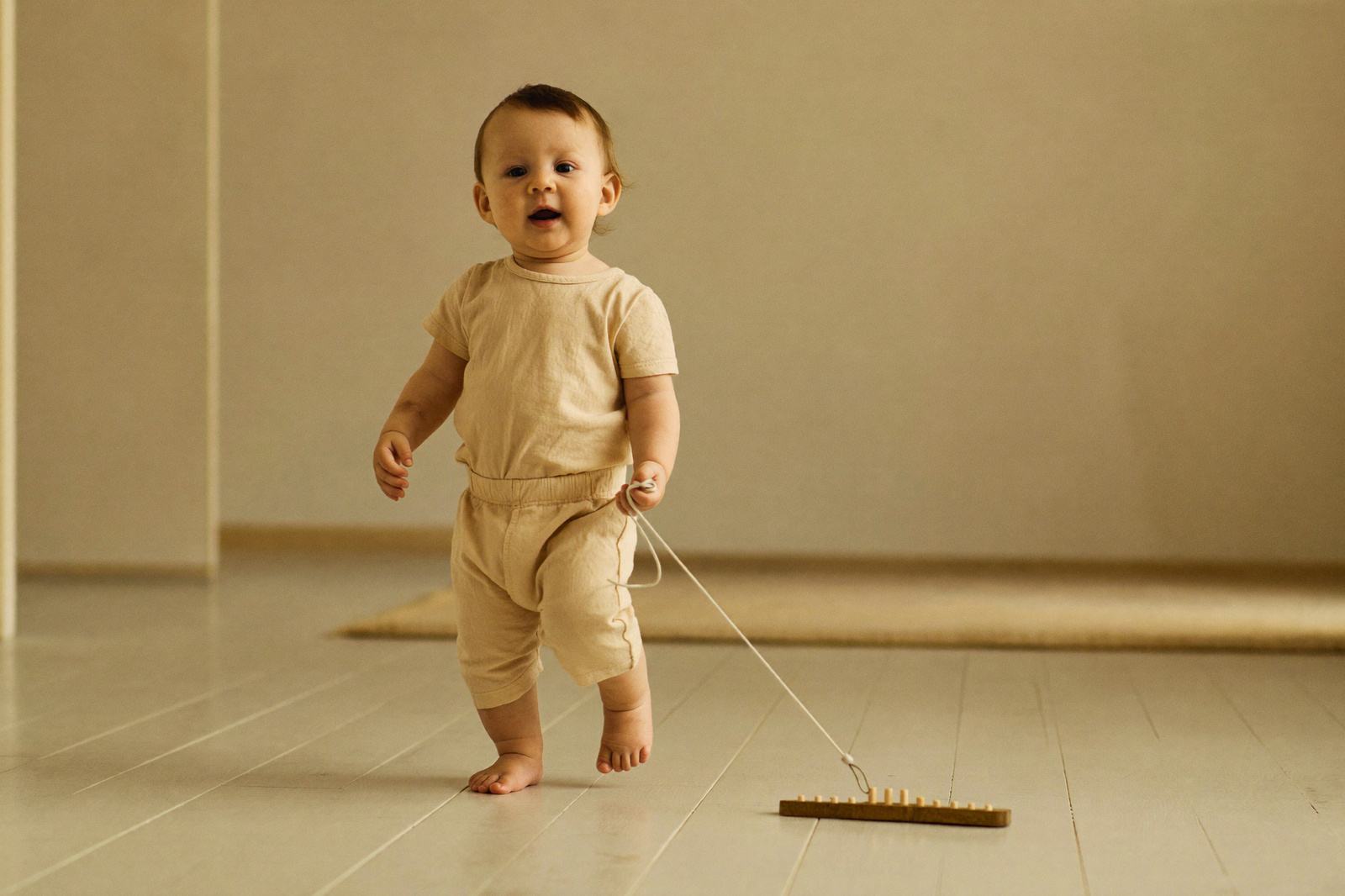 Niño de año y medio caminando solo por un pasillo iluminado, sin agarrarse de nada