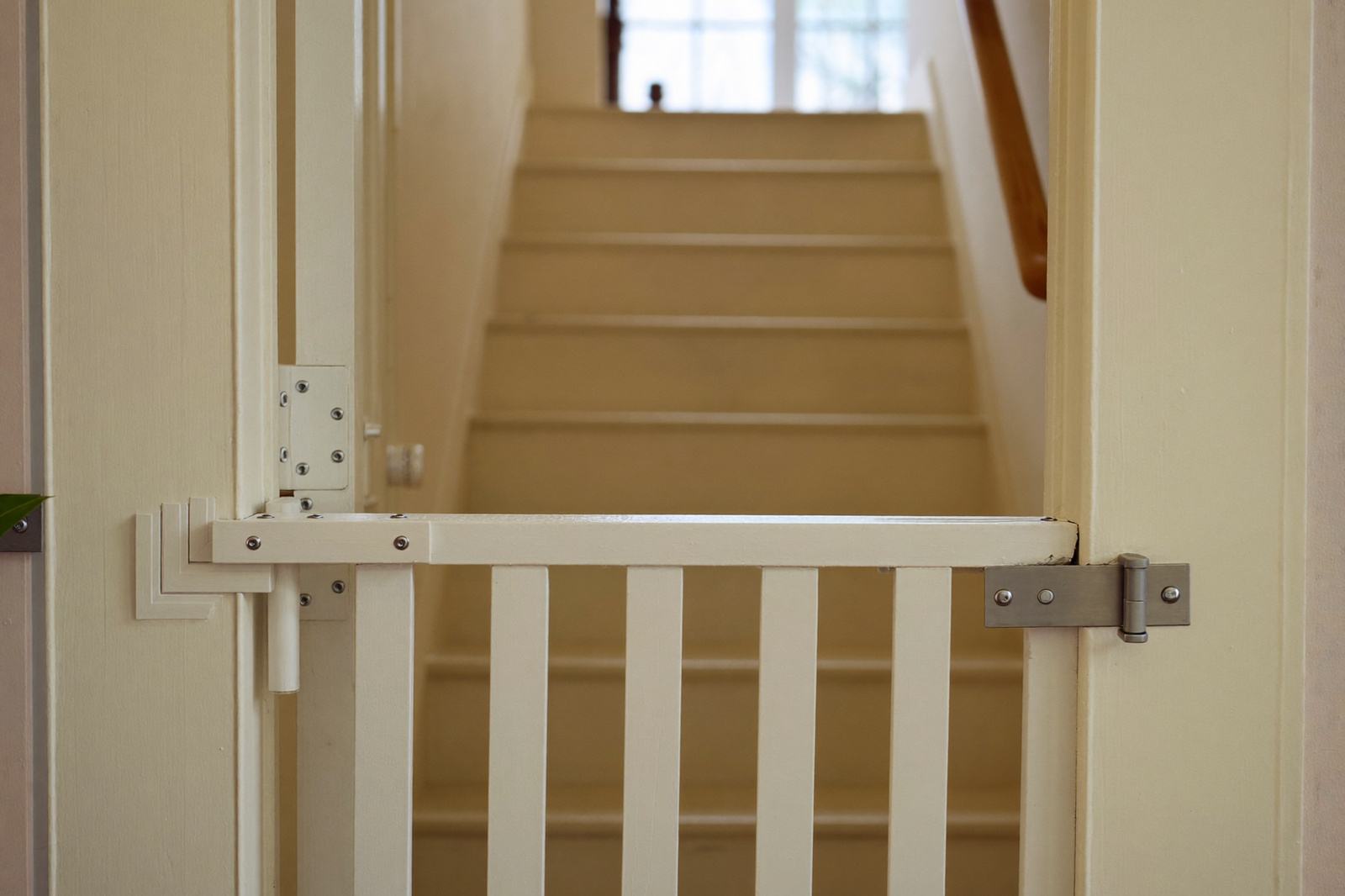 Reja de seguridad instalada al inicio de una escalera de madera en una casa