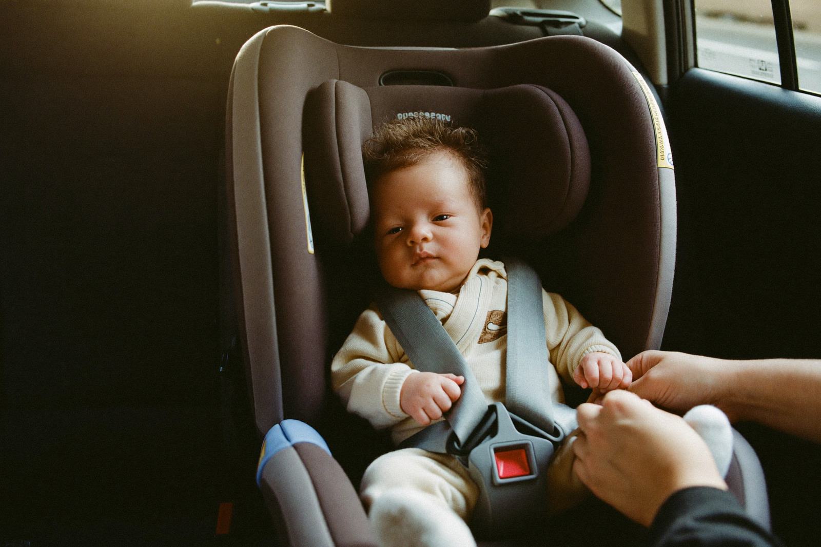 Silla de coche para bebé instalada mirando hacia atrás en el asiento trasero de un auto