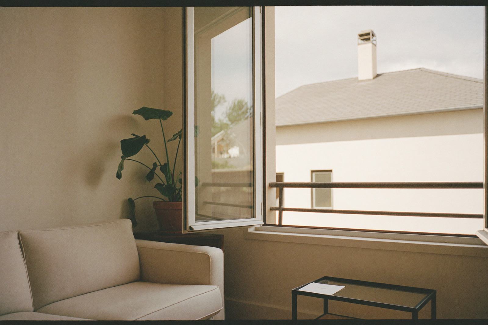 Sala de una casa con ventana abierta y luz de tarde, sin ceniceros a la vista