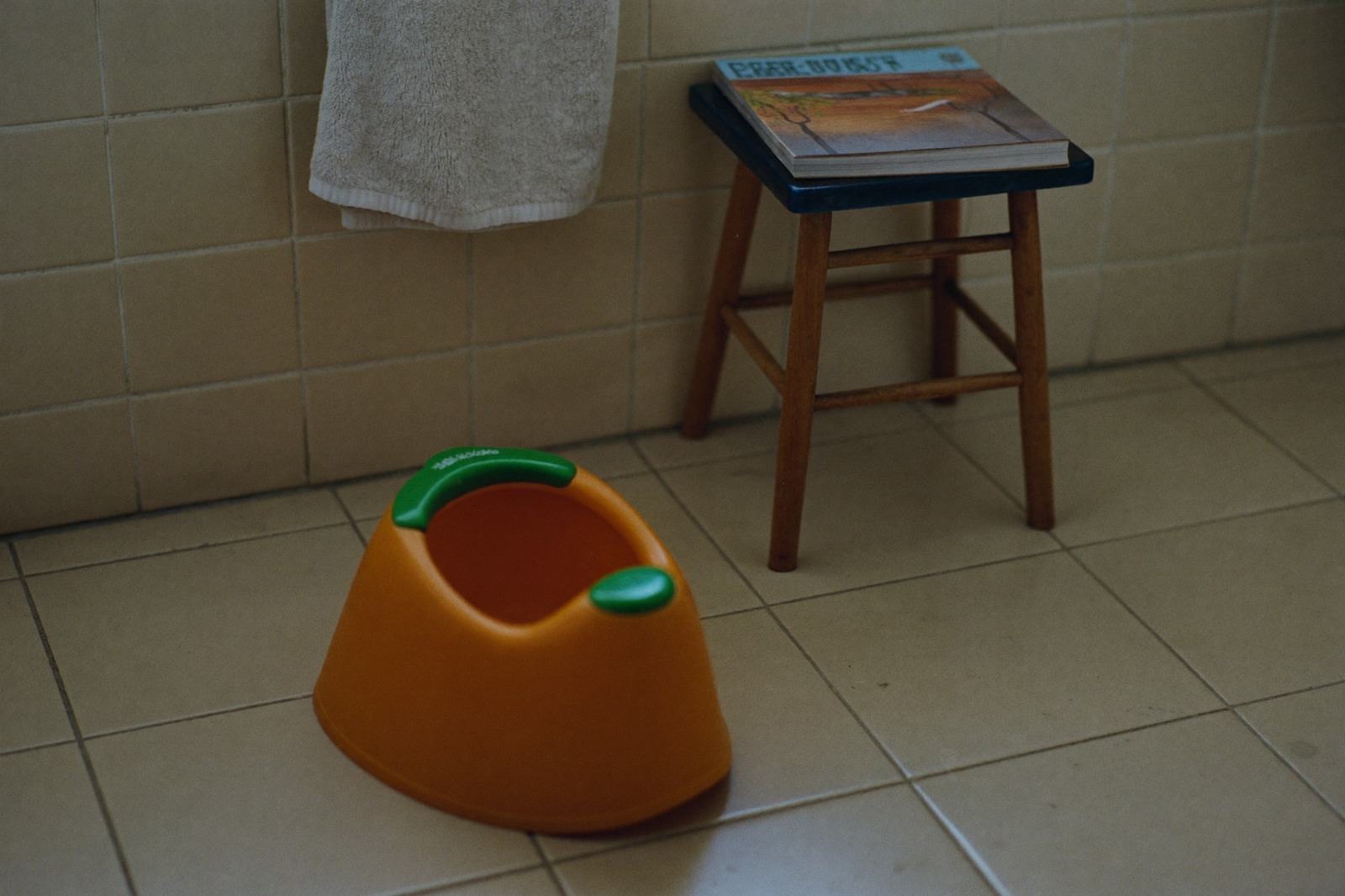 Bacinica infantil de plástico colocada sobre el piso de un baño con luz natural