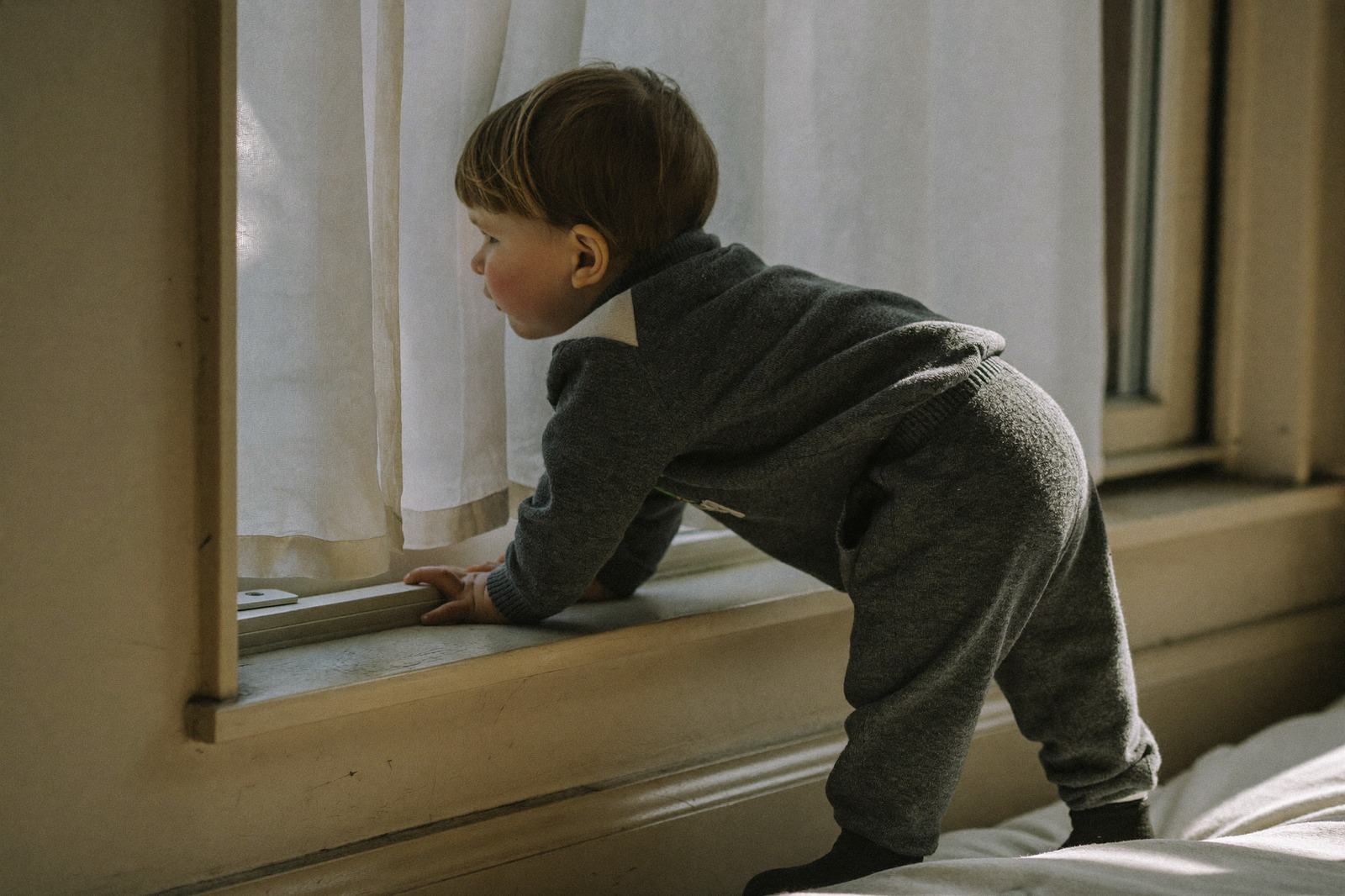 Ventana de un salón infantil vista desde el pasillo, con luz de la mañana