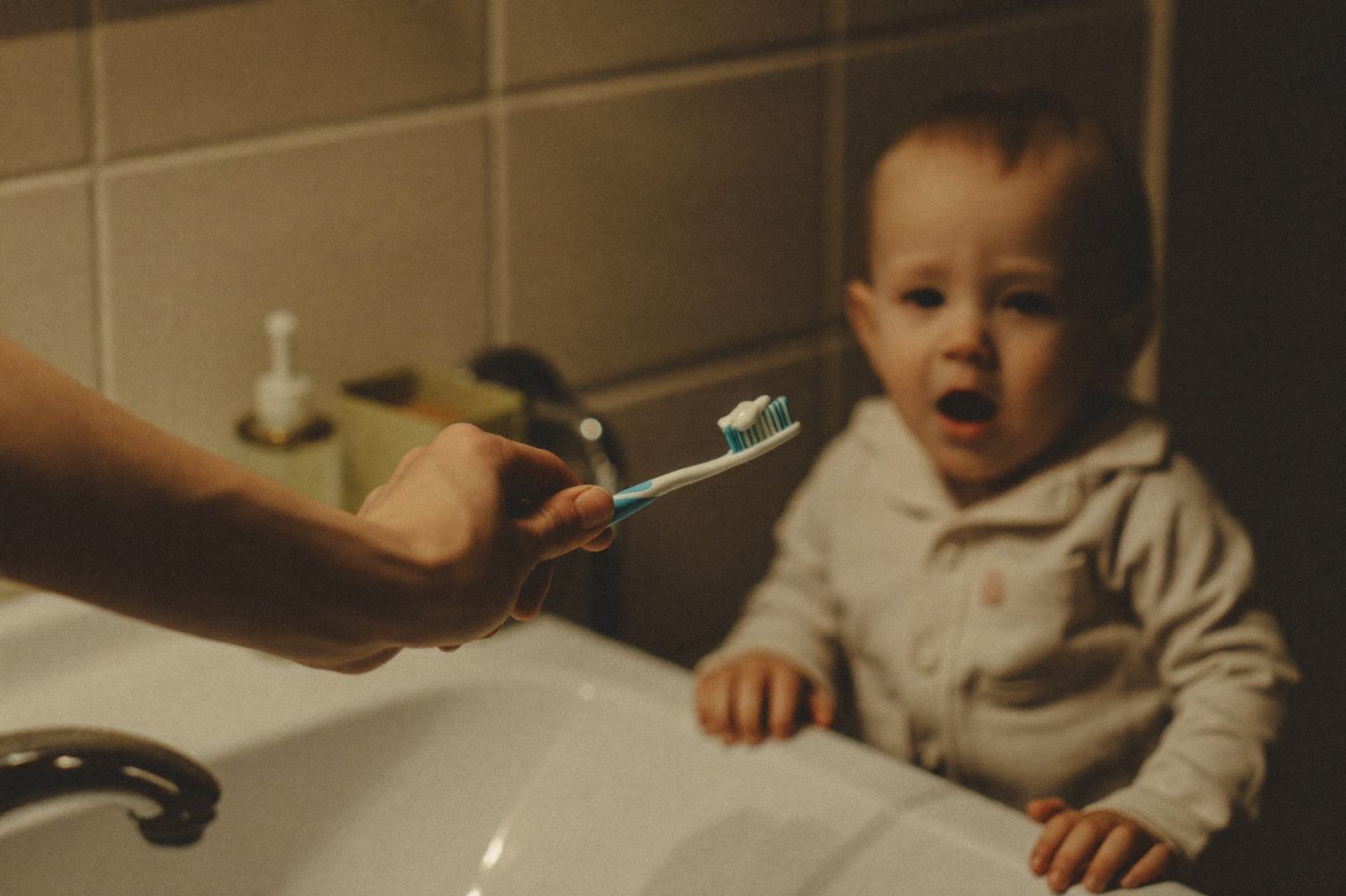 Cepillo de dientes infantil y una gasa doblada sobre un lavabo