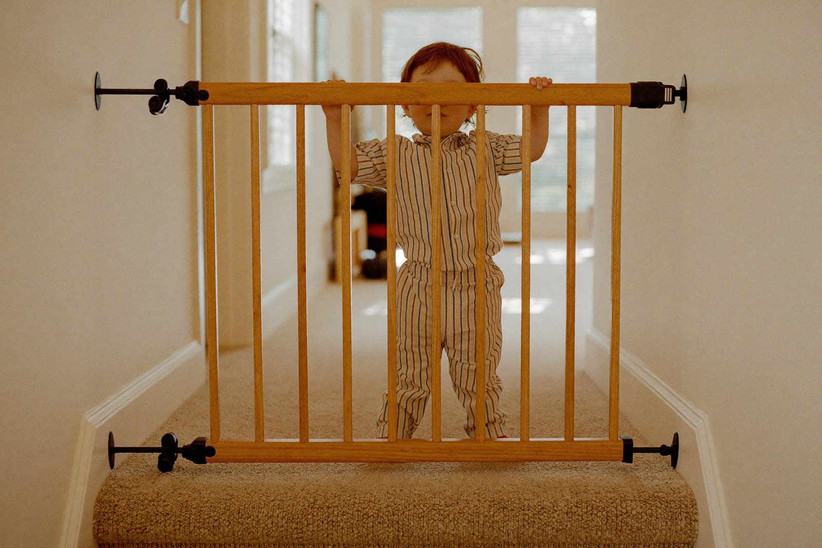 Reja de seguridad instalada al inicio de una escalera de madera en una casa