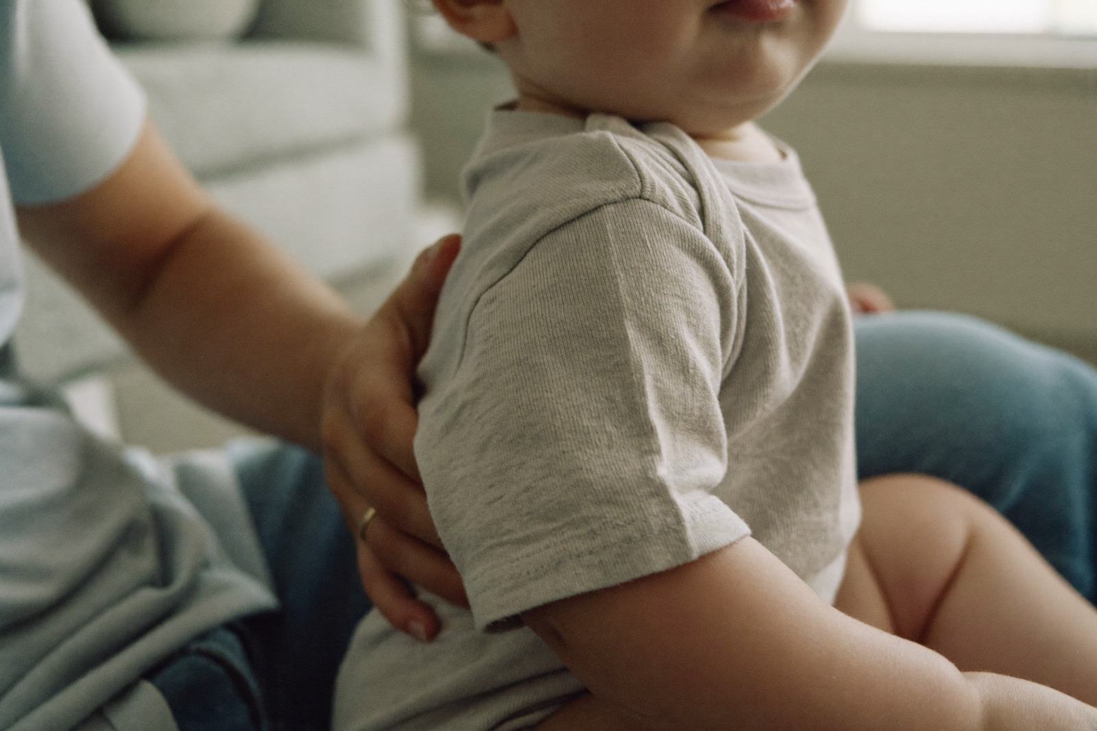 Mano de un adulto apoyada sobre el hombro de un niño pequeño